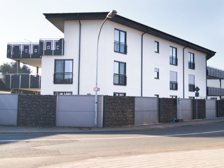 Mehrfamilienhaus‑Neubau mit 9 Wohneinheiten, bodentiefe anthrazitgraue Fenster und Rollläden als Sonnenschutz