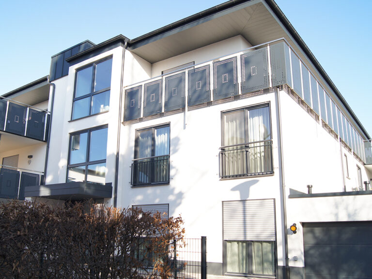 Mehrfamilienhaus‑Neubau mit 9 Wohneinheiten, bodentiefe anthrazitgraue Fenster und Rollläden als Sonnenschutz