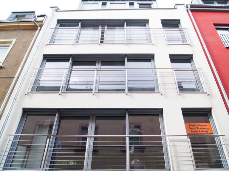 Modernes Wohn‑ und Geschäftshaus am Roßmarkt in Aschaffenburg mit großformatigen Fenstern Haustüre, Faltanlage und insgesamt vier Wohneinheiten über der Gewerbeeinheit.