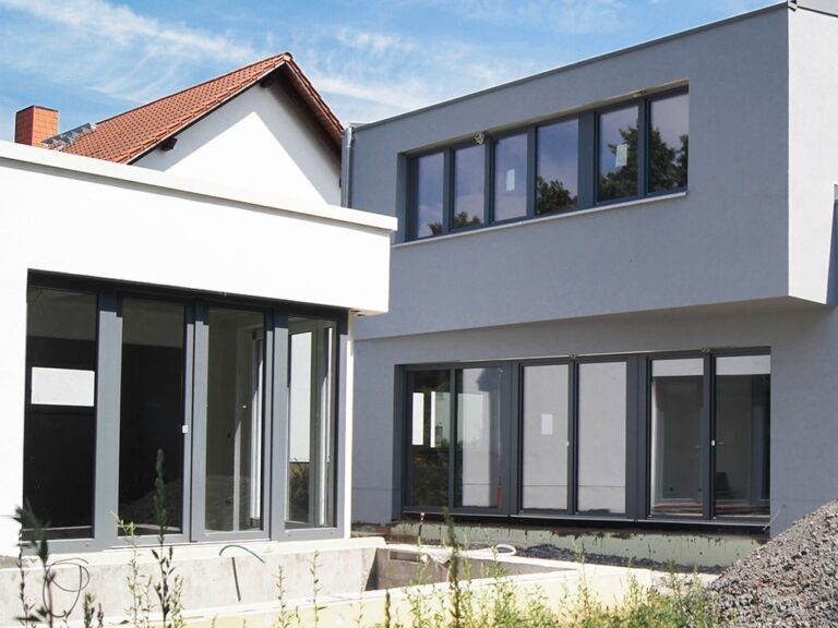 Neubau eines modernen Einfamilienhauses in Seligenstadt, großen anthrazitfarbenen Fensterelementen und bodentiefen Balkontüren zum späteren Gartenbereich